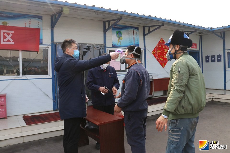 2020年2月1日，济矿物流公司新型冠状病毒感染的肺炎防控领导小组办公室成员，在职工餐厅门口为即将用餐职工进行体温监测和手部消毒。（王传钧 摄）.JPG